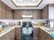 The kitchen has dark wood cabinets and white countertops with a black range at 2803 Charing Cross Way, Orlando, FL 32837