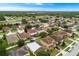 An aerial view of a community with a pond, trees, and multiple homes, showcasing the neighborhood layout at 2806 Polson Dr, Kissimmee, FL 34758