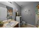 The neutral-toned bathroom is decorated with plants, a cabinet and a single vanity sink at 2806 Polson Dr, Kissimmee, FL 34758