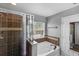 A soaking tub next to the window with tiled walk-in shower with glass doors at 2806 Polson Dr, Kissimmee, FL 34758