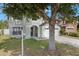Two-story home with attached two-car garage, a large tree, and well-maintained landscaping at 2806 Polson Dr, Kissimmee, FL 34758