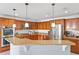 Kitchen with wood cabinets, stainless steel appliances, countertop overhang and pendant lighting at 2806 Polson Dr, Kissimmee, FL 34758