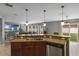 Open kitchen with countertop overhang, stainless steel appliances and view into living room at 2806 Polson Dr, Kissimmee, FL 34758