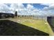 View of the fenced backyard and lake featuring a screened-in porch and view of other houses at 2926 Wordsmith Rd, Kissimmee, FL 34746