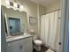 Cozy bathroom featuring a single vanity, toilet and shower with white curtain at 2926 Wordsmith Rd, Kissimmee, FL 34746