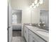 Bright bathroom features a double sink vanity, decorative lighting, tile floors, and an open doorway into a bedroom at 2926 Wordsmith Rd, Kissimmee, FL 34746