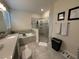 Bright bathroom featuring a soaking tub with tile surround, separate shower and a vanity with stone countertop at 2926 Wordsmith Rd, Kissimmee, FL 34746