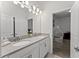 Bright bathroom features a double sink vanity, decorative lighting, and an open doorway into a decorated bedroom at 2926 Wordsmith Rd, Kissimmee, FL 34746