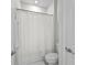 Bright bathroom featuring a white shower curtain, toilet, towel rack, and a closed door at 2926 Wordsmith Rd, Kissimmee, FL 34746