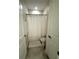 Compact bathroom featuring a white shower curtain, toilet, and neutral colored tile flooring at 2926 Wordsmith Rd, Kissimmee, FL 34746