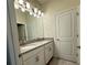 Bathroom featuring double vanity with grey countertops, white cabinets and a large mirror at 2926 Wordsmith Rd, Kissimmee, FL 34746