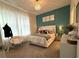 Charming bedroom featuring a stylish tufted headboard bed, teal accent wall and a modern chandelier at 2926 Wordsmith Rd, Kissimmee, FL 34746