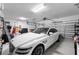 Garage featuring a white car, overhead storage, and epoxy flooring at 2926 Wordsmith Rd, Kissimmee, FL 34746