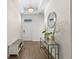Hallway with wood-look floors, console table, mirror, bench, and front door entrance at 2926 Wordsmith Rd, Kissimmee, FL 34746