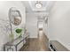 Bright hallway with wood-look floors, decorative mirror, console table, and a view into the home at 2926 Wordsmith Rd, Kissimmee, FL 34746