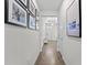 Hallway with wood-look floors and artwork, leading to the front door and main living areas at 2926 Wordsmith Rd, Kissimmee, FL 34746