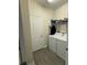 Bright laundry room with white washer and dryer and gray wood-look tile flooring and wire shelving at 2926 Wordsmith Rd, Kissimmee, FL 34746