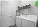 Functional laundry room featuring modern appliances, storage shelves, and convenient access at 2926 Wordsmith Rd, Kissimmee, FL 34746