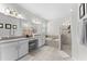 Bright main bathroom featuring a double sink vanity, soaking tub, and glass enclosed shower at 2926 Wordsmith Rd, Kissimmee, FL 34746