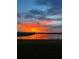 Reflective sunset over water, viewed from a property's grassy backyard with a black fence at 2926 Wordsmith Rd, Kissimmee, FL 34746