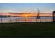 Beautiful sunset over the water, seen from a grassy backyard with a black metal fence at 2926 Wordsmith Rd, Kissimmee, FL 34746
