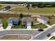 An aerial view showcasing a residential street with well-maintained homes and green spaces at 3033 Beau Loop, Tavares, FL 32778