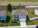 An aerial perspective capturing a grey home featuring a well-kept lawn and a fenced backyard at 3033 Beau Loop, Tavares, FL 32778