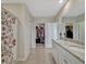 Bathroom with double vanity, granite countertop, floral shower curtain, and closet access at 3033 Beau Loop, Tavares, FL 32778