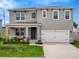 Charming two-story home featuring a well-maintained lawn, covered porch with bench, and a two-car garage at 3033 Beau Loop, Tavares, FL 32778