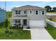 Two-story home featuring a well-maintained lawn, covered porch with bench, a two-car garage and play set at 3033 Beau Loop, Tavares, FL 32778