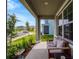 Inviting covered front porch with seating, beautiful landscaping, and a view of the quiet neighborhood street at 3033 Beau Loop, Tavares, FL 32778