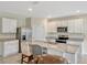 Modern kitchen boasts stainless steel appliances, sleek white cabinetry, and granite countertops for a modern, functional space at 3033 Beau Loop, Tavares, FL 32778