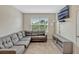 Living room with gray sectional sofa, large window, and a mounted television at 3033 Beau Loop, Tavares, FL 32778