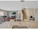 Open-concept home with stairs, living room, and granite island with seating providing seamless flow and connectivity at 3033 Beau Loop, Tavares, FL 32778