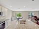 Open concept kitchen and living area features granite island, dining table, and leather seating, ideal for entertaining at 3033 Beau Loop, Tavares, FL 32778