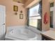 Bathroom with a modern soaking tub under a window with floral curtains at 3137 Timucua Cir, Orlando, FL 32837