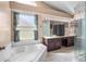 Luxurious primary bath with soaking tub, dual vanities, tile floors, and glass-enclosed shower at 3137 Timucua Cir, Orlando, FL 32837