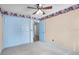 Bright bedroom with a gray carpet, colorful wallpaper border, and light blue closets at 3137 Timucua Cir, Orlando, FL 32837