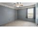 Neutral bedroom with carpeted floor, ceiling fan, and a window dressed with curtains for soft, natural light at 3137 Timucua Cir, Orlando, FL 32837