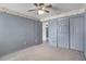 Bedroom with gray walls, carpet flooring, ceiling fan, and closet with sliding doors at 3137 Timucua Cir, Orlando, FL 32837