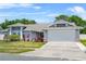 Well-maintained single-story home with a two-car garage and vibrant landscaping under a sunny sky at 3137 Timucua Cir, Orlando, FL 32837