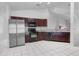Modern kitchen with stainless steel appliances, dark cabinetry, and white tile floors at 3137 Timucua Cir, Orlando, FL 32837
