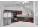 Well-lit kitchen with dark cabinets, stainless steel refrigerator, and sleek black appliances at 3137 Timucua Cir, Orlando, FL 32837