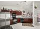Modern kitchen with stainless steel appliances, ample dark wood cabinetry, and tile floors for easy cleaning at 3137 Timucua Cir, Orlando, FL 32837