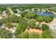 Community aerial view showcasing a lake with a fountain, tennis court, and playground surrounded by lush trees at 3534 Woodley Park Pl, Oviedo, FL 32765