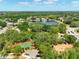 Overhead view showcases neighborhood tennis courts and playground near a scenic lake at 3534 Woodley Park Pl, Oviedo, FL 32765