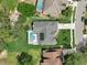 Aerial view showcases home with screened pool, solar panels, and landscaped yard at 3534 Woodley Park Pl, Oviedo, FL 32765