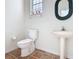 Half bath with pedestal sink, terracotta tile floor, and decorative mirror at 3534 Woodley Park Pl, Oviedo, FL 32765