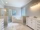 Spacious bathroom with dual vanities, walk-in shower, soaking tub, and tile flooring at 3534 Woodley Park Pl, Oviedo, FL 32765