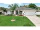 Beautiful exterior view of a well-maintained home with lush green lawn, palm trees, and a driveway at 3534 Woodley Park Pl, Oviedo, FL 32765